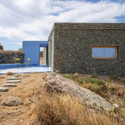 Το λουλακί χρώμα φωτίζει μια πέτρινη κατοικία στη Σίφνο που λειτουργεί σαν σύγχρονη θεμωνιά 